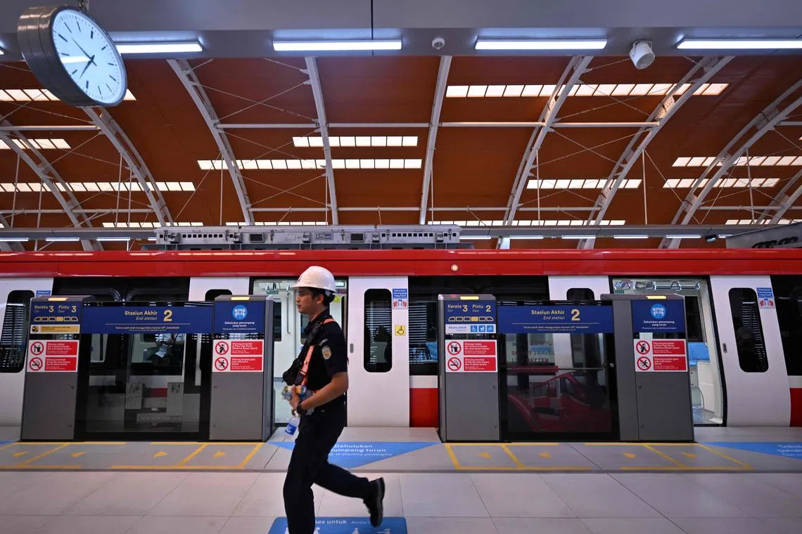 An employee walking past carriages at a platform on Jakarta's new light rail transit (LRT) on Aug 3. 