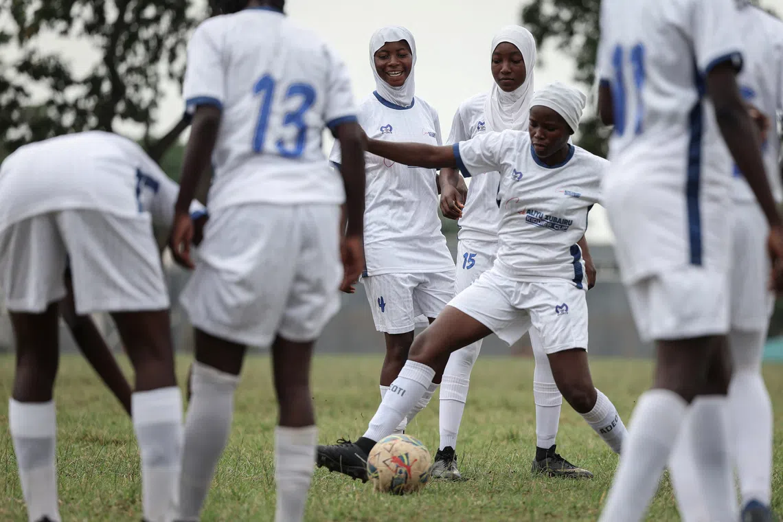 Salaudeen Ganiyah, 18, Bashirat Omotosho, 19, and Adeoti Elizabeth, 18, team members of the Model Queens Football Academy, warm-up before the Youth Tournament final match with Kwara Ladies FC in Ilorin, Kwara State, Nigeria, August 29, 2025. REUTERS/Sodiq Adelakun