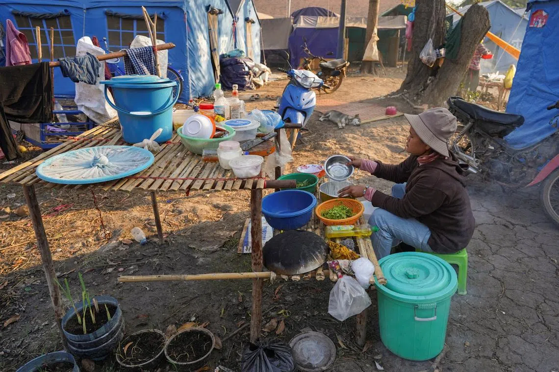 A woman prepares food at Wat Chansi refugee camp, where residents from Prey Chan village and Chouk Chey village have been staying since clashes between Thailand and Cambodia, in Banteay Meanchey province, Cambodia, February 11, 2026. REUTERS/Soveit Yarn