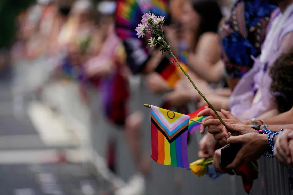 FILE PHOTO: People hold flowers and flags during the annual LGBTQ+ Capital Pride parade in Washington, U.S., June 8, 2024. REUTERS/Nathan Howard/File Photo