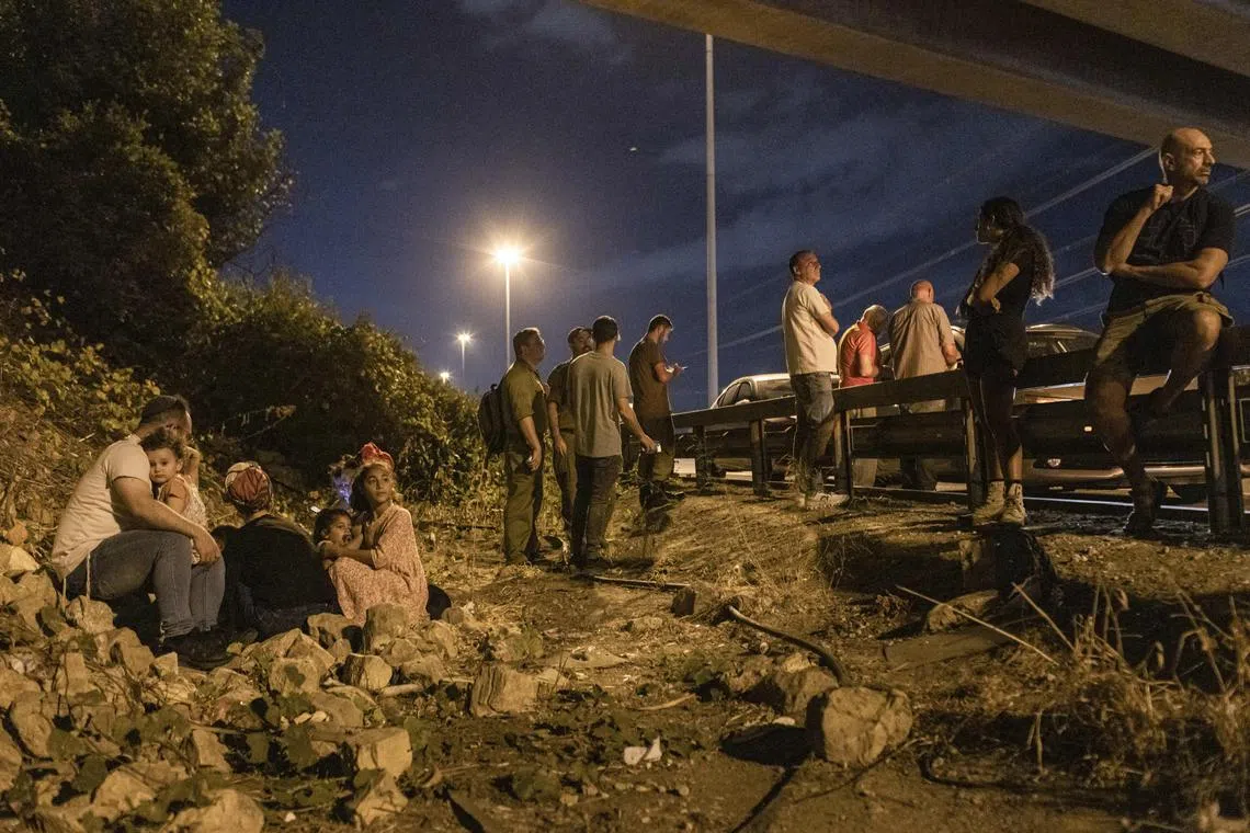 People taking cover from an Iranian rocket attack on Israel, near Kfar Saba, on Oct 1. 