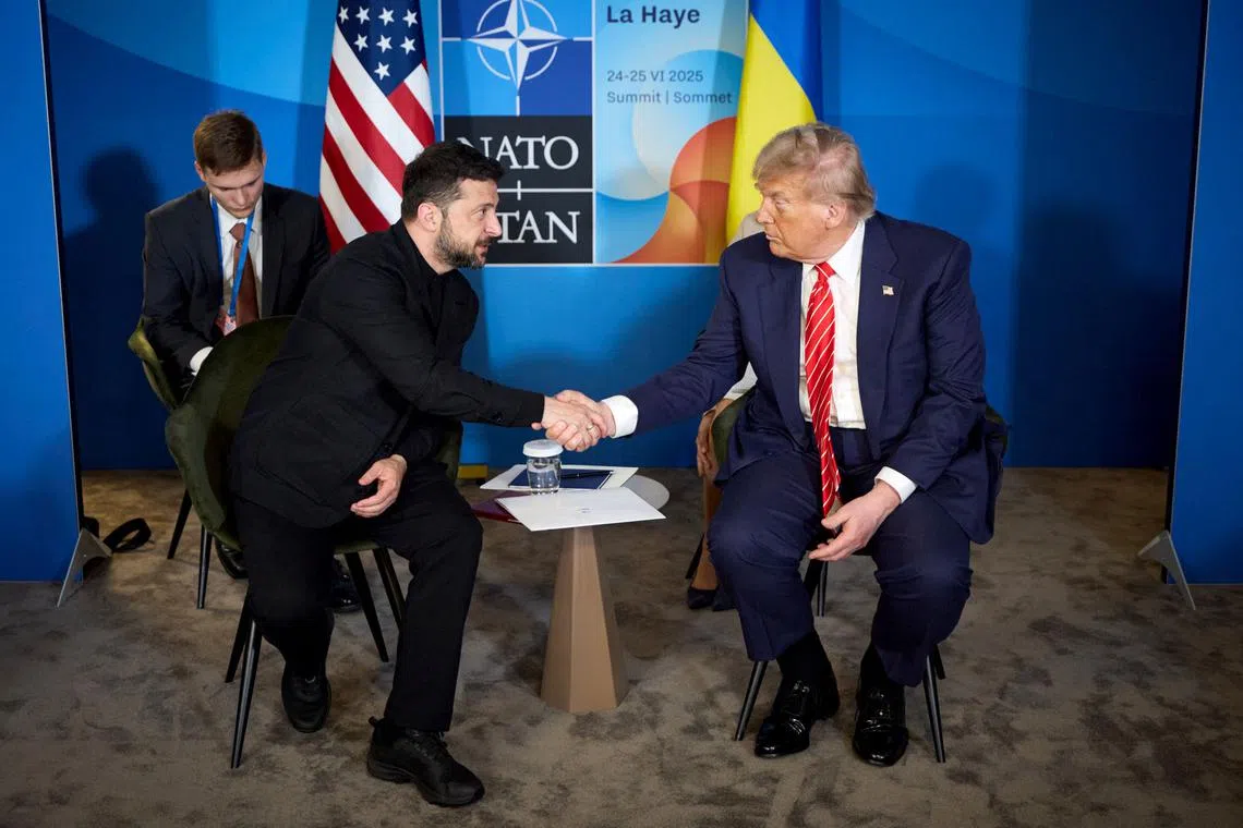 Ukraine's President Volodymyr Zelensky (left) shaking hands with US President Donald Trump on the sideline of the NATO summit in June.