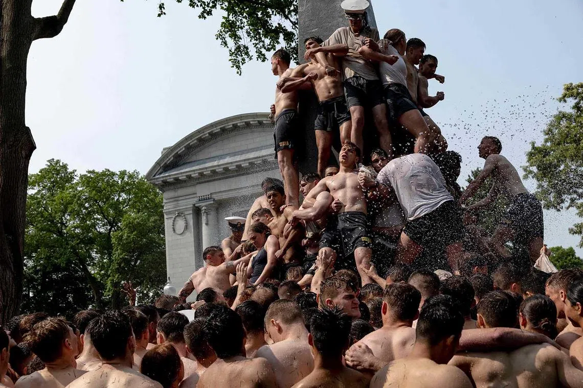 Freshmen known as "Plebes" participate in the annual Herndon Monument Climb at the U.S. Naval Academy on May 17 in Annapolis, Maryland. In just over two and a half hours, members of the 2026 midshipmen's class worked to scale the 21-foot greased monument and replace a “dixie cup” hat with the upperclassmen's hat, signifying the end of their “plebe” or first year at the academy. 