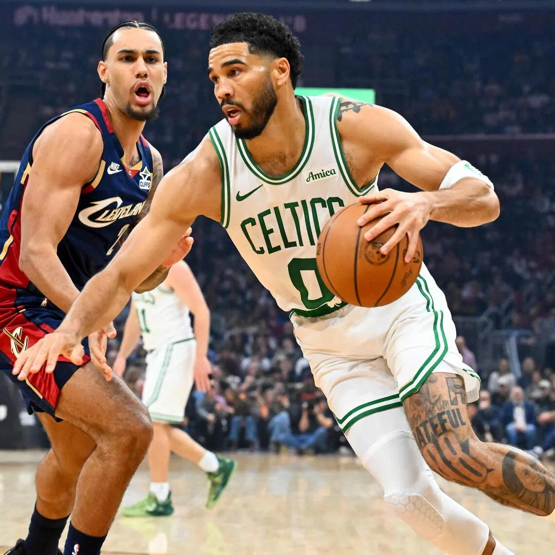 Jayson Tatum of the Boston Celtics drives to the basket around Jaylon Tyson of the Cleveland Cavaliers during the first quarter at Rocket Arena.