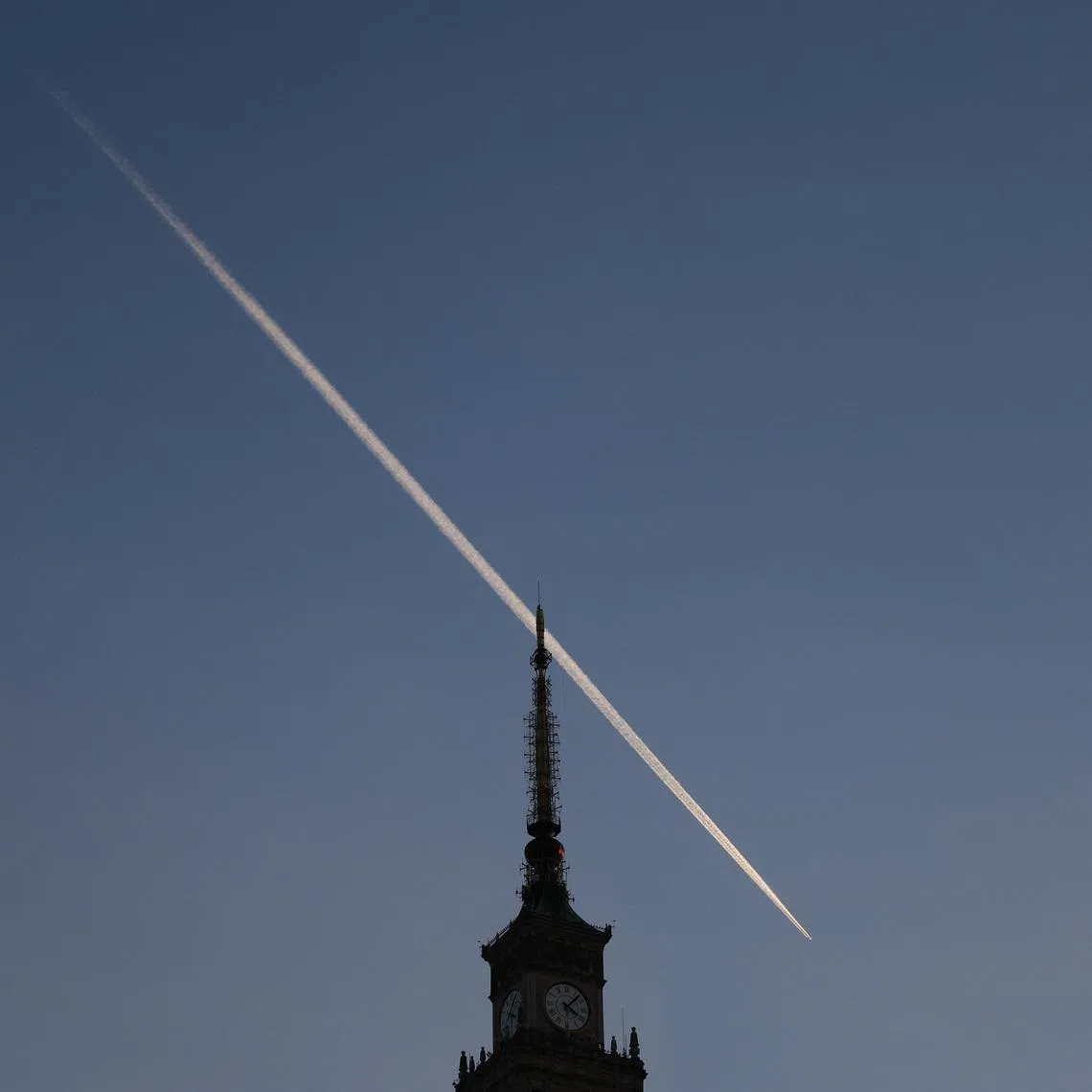 A plane trail is seen in the sky above the Palace of Culture and Science in Warsaw, Poland, October 28, 2024. REUTERS/Kacper Pempel