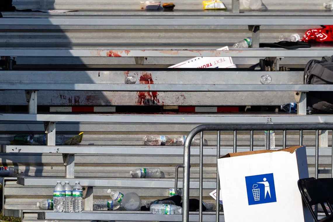 Blood stains the bleachers after a shooting at a campaign rally for former President Donald Trump. Trump was rushed to a hospital after a shooting just minutes into his rally that left one rally attendee and the suspected gunman dead, according to a U.S. official and two people also briefed on the matter.