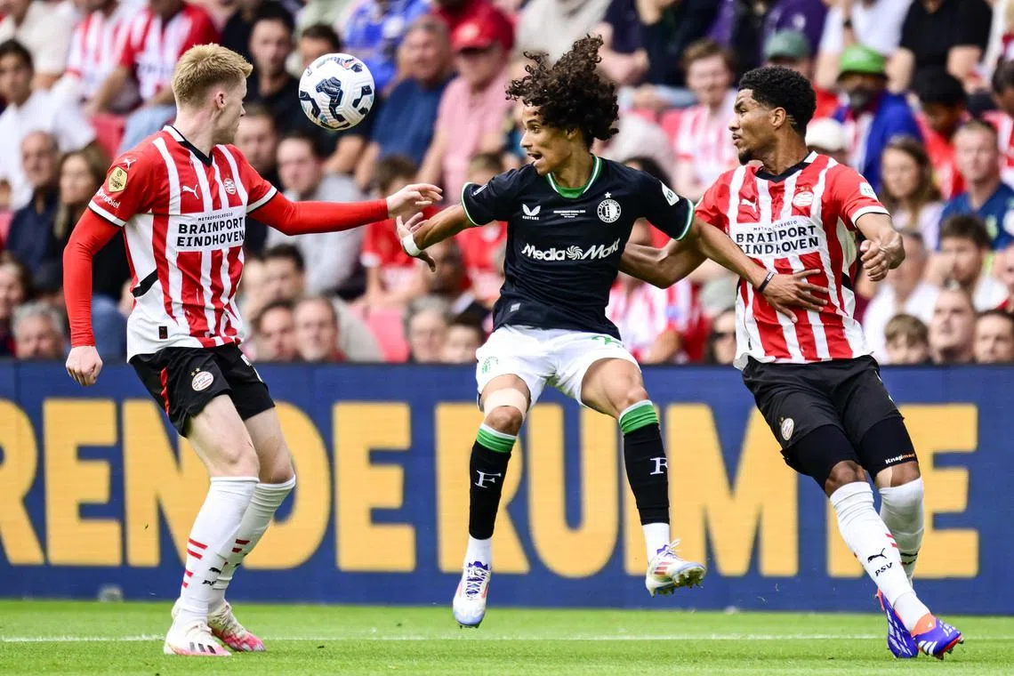 PSV Eindhoven's Jerdy Schouten (left) and Malik Tillman marking Feyenoord's Gjivai Zechiel in the 28th edition of the Johan Cruijff Shield football match on Aug 4, 2024.