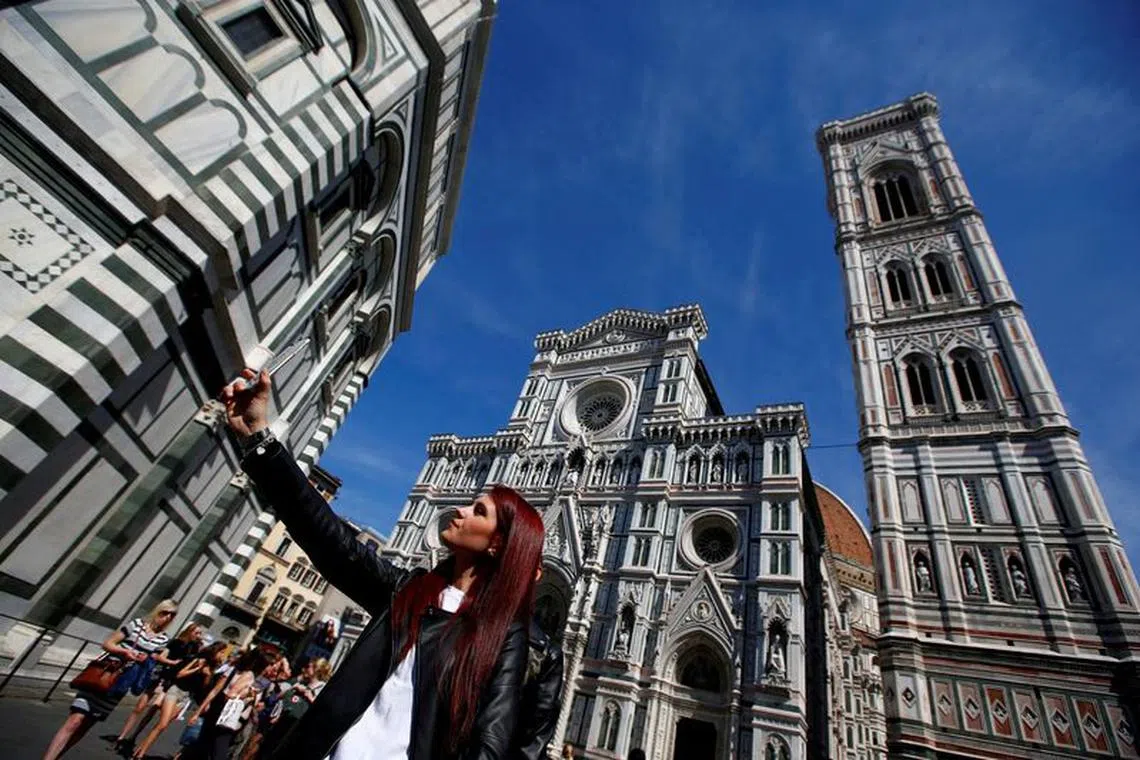 FILE PHOTO: A tourist takes a selfie in Florence, Italy March 31, 2017. REUTERS/Tony Gentile/File Photo