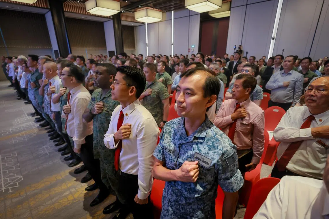National servicemen and invited guests reciting the SAF pledge at an SAF rededication ceremony on June 30.