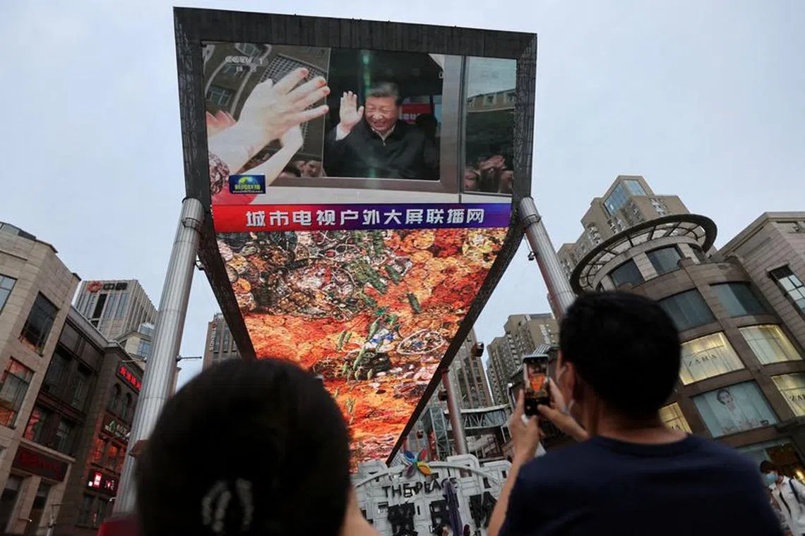 FILE PHOTO: A giant screen shows news footage of Chinese President Xi Jinping visiting Xinjiang Uyghur Autonomous Region, at a shopping centre, in Beijing, China, July 15, 2022. REUTERS/Tingshu Wang/File Photo