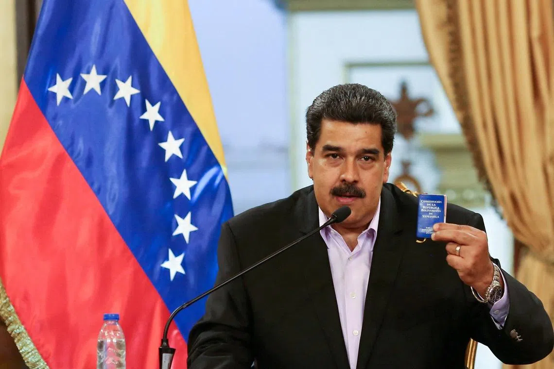 FILE PHOTO: Venezuela's President Nicolas Maduro holds a copy of the Venezuelan constitution while he speaks during a meeting with members of the Venezuelan diplomatic corp after their arrival from the United States, at the Miraflores Palace in Caracas, Venezuela January 28, 2019. Miraflores Palace/Handout via REUTERS/File Photo