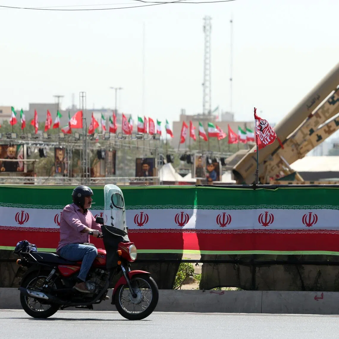 A man drives past Iranian missiles ‘Zolfaghar’ on display at the Azadi square in Tehran, Iran.