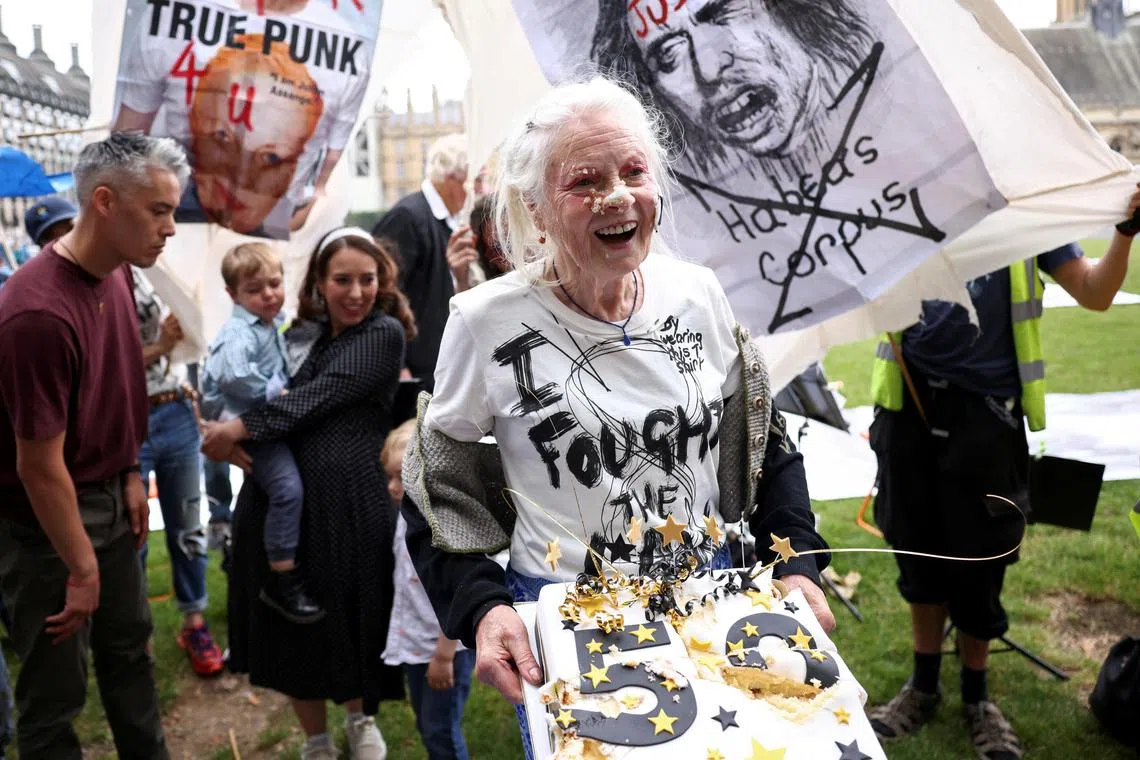 In a 2021 photo, fashion designer Vivienne Westwood poses with a cake after smearing it on her face as she attends a picnic protest marking Wikileaks founder Julian Assange's 50th birthday, in London.