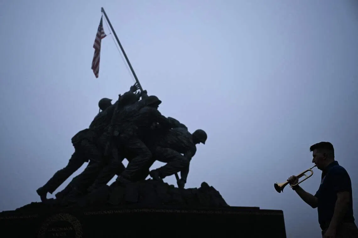 Ryan Brewer, a military bandsman and member of the Doughboy Foundation, playing "Taps" at the Marine Corps War Memorial to mark Memorial Day in Arlington, Virginia, U.S on May 25, 2026. 