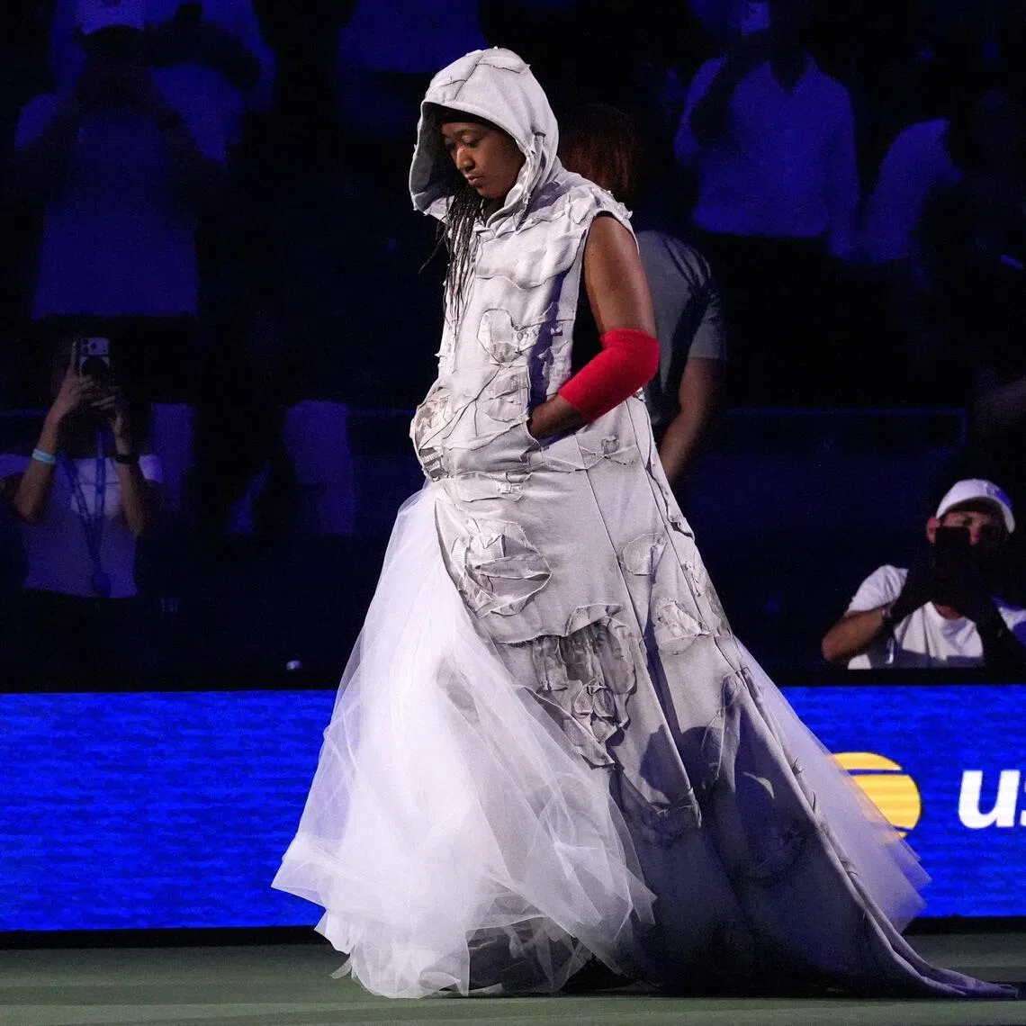 Naomi Osaka arrived at the US Open on Aug 31  in a hooded tunic featuring patchwork-style panels adorned with press clippings from past events.