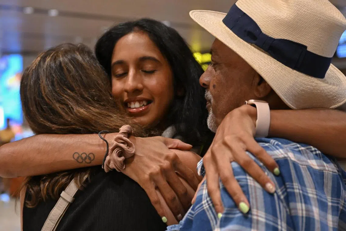 Shanti Pereira hugging her parents Clarence and Jeet Pereira after arriving at Changi Airport on Friday.