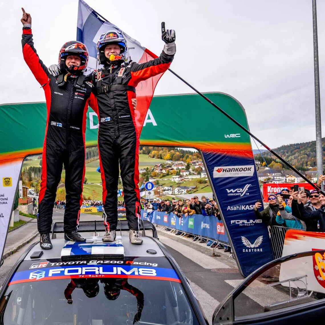 Finnish driver Kalle Rovanpera (right) and co-driver Jonne Halttunen stand on top of their Toyota GR Yaris Rally1 car as they celebrate their victory on the final day of the World Rally Championship Central European Rally at the end of the SS18 Muehltal stage in the village of Peilstein near Rohrbach, Upper Austria on Oct 19, 2025.