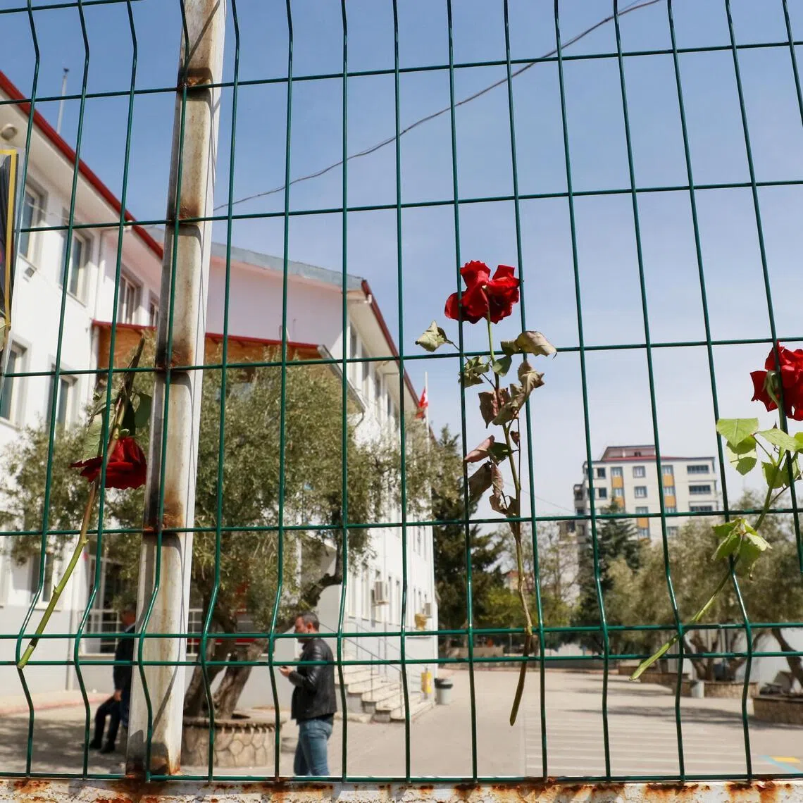 Flowers are hung on the fence of a school where a shooting took place yesterday, in the south-eastern province of Kahramanmaras, Turkey, on April 16.