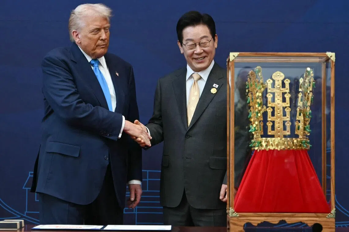 US President Donald Trump (left) with South Korean President Lee Jae Myung during a ceremony when he was presented with a replica of the gold crown from the Silla dynasty, on Oct 29.