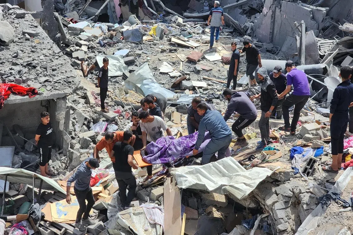 Palestinians carrying the body of a person killed in an Israeli strike on a house, in Jabalia refugee camp, in the northern Gaza Strip, on May 18.
