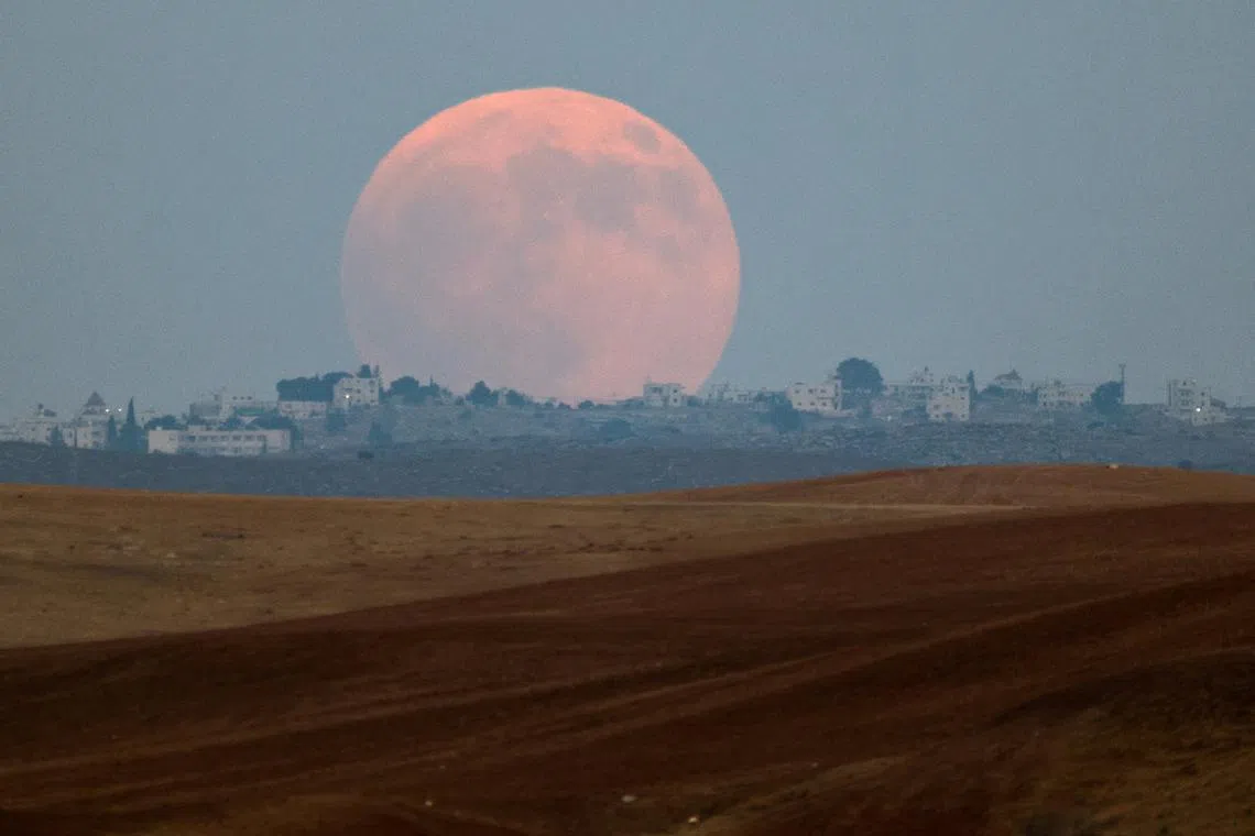 The blood moon rises over the West Bank, as seen from the Negev desert in Israel, on Sept 7, 2025. 