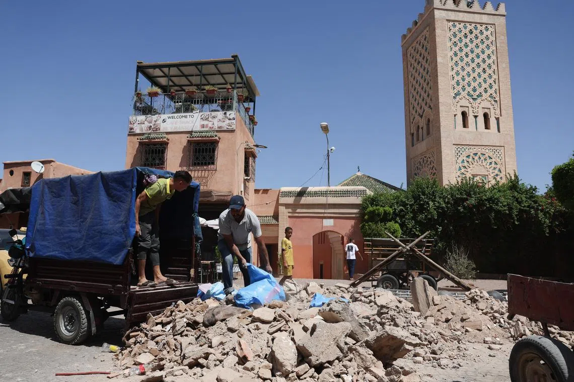 People clean the debris of damaged buildings that collapsed in a powerful earthquake in Marrakech, Morocco.