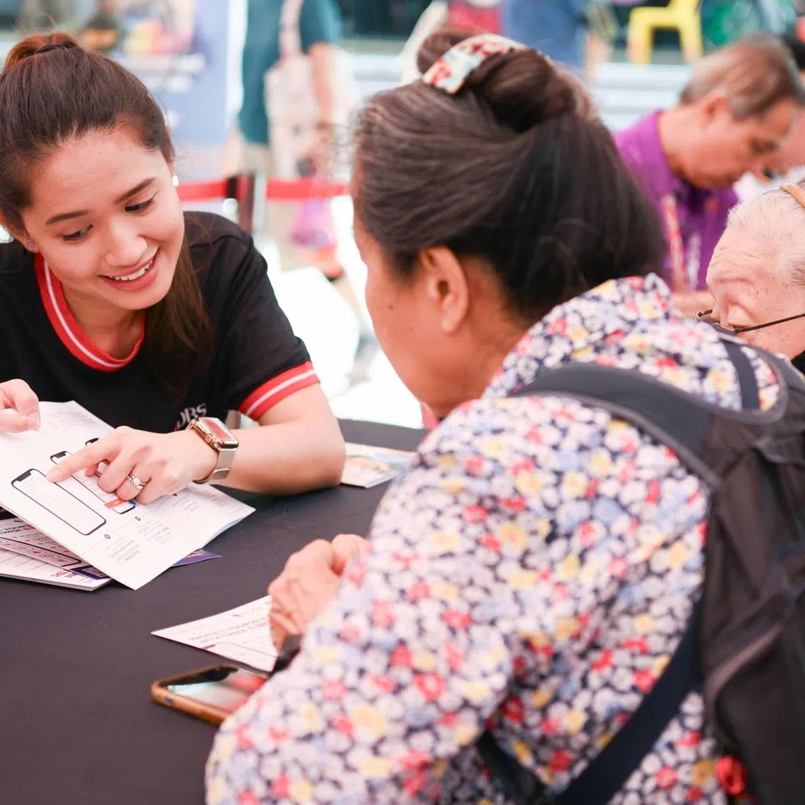 星展基金会和储蓄银行在红山景巴刹与熟食中心举办“街坊歌台欢乐”活动，银行义工与现场公众分享数码科技知识。（星展银行提供）