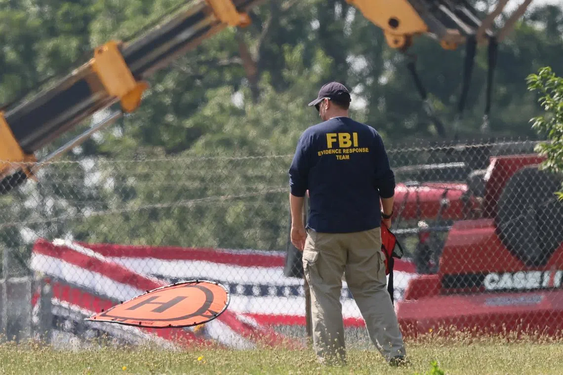 FILE PHOTO: A member of the FBI Evidence Response Team, works near the building where a gunman was shot dead by law enforcement, near the stage where Republican presidential candidate and former U.S. President Donald Trump survived an assassination attempt during a rally the day before, in Butler, Pennsylvania, U.S. July 15, 2024. REUTERS/Brendan McDermid/File Photo