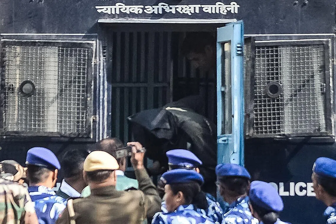 Security personnel escort suspect Amir Rashid Ali from a police vehicle at the Patiala House Court.