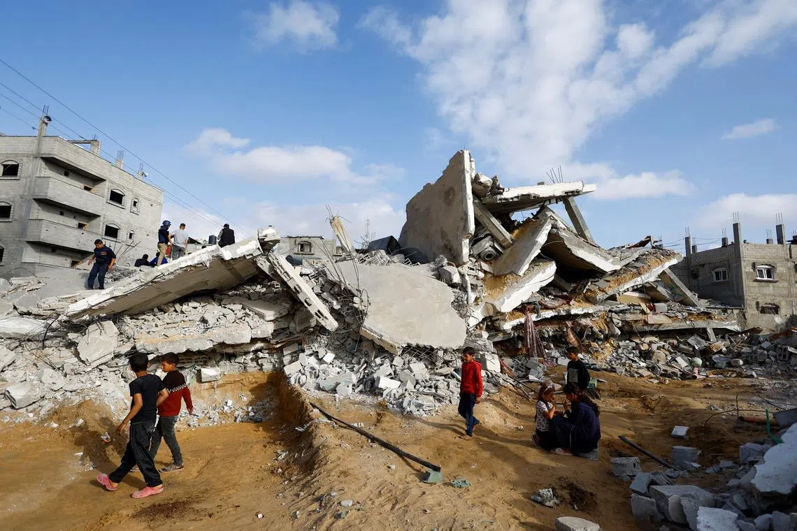 Palestinians inspect the site of an Israeli strike on a house in Rafah, April 21, 2024. REUTERS/Mohammed Salem