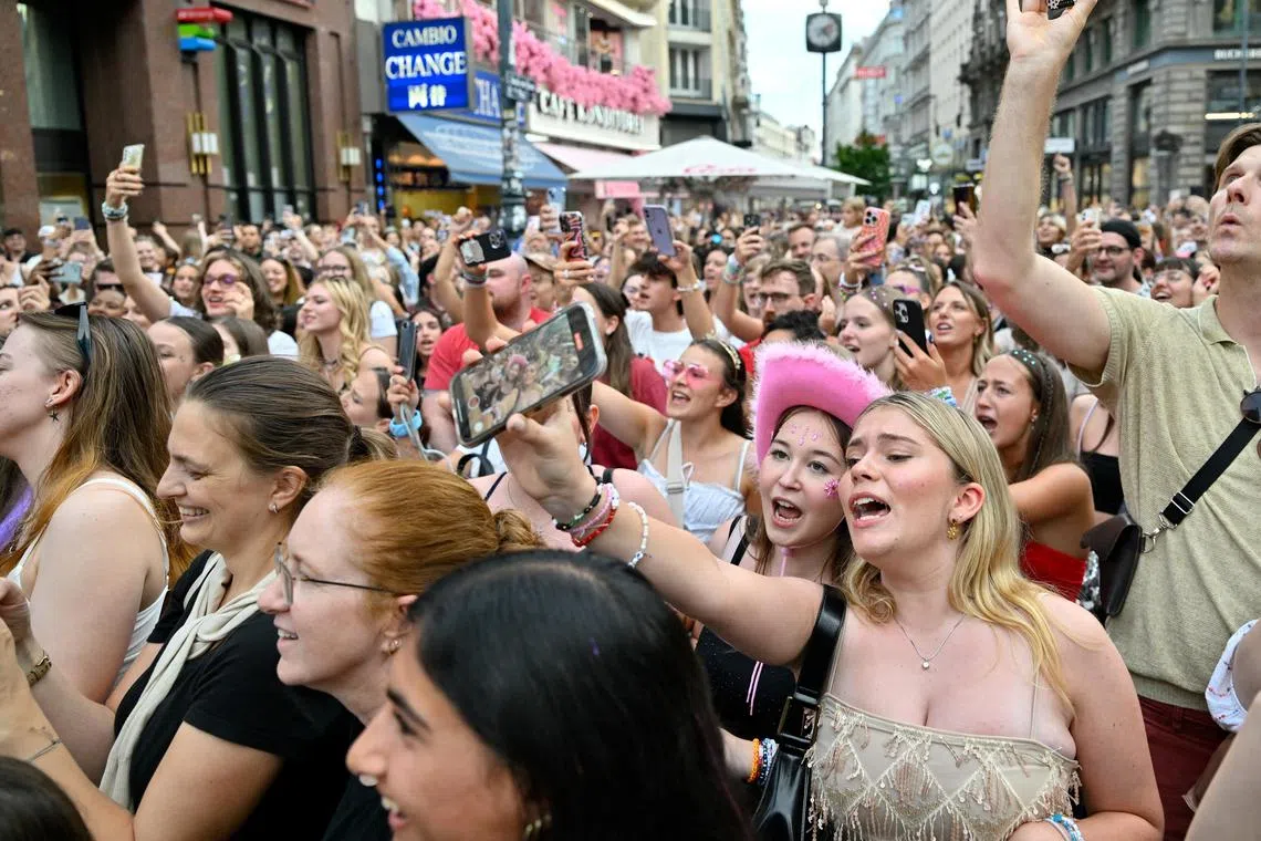 Fans of Taylor Swift react as they sing together in front of St. Stephen's Cathedral following the cancellation of three Taylor Swift concerts in Vienna.