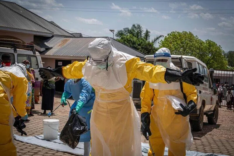 Health workers are sprayed with disinfectant on May 25 after coming into contact with the body of a person suspected of having died from Ebola in Bunia, Democratic Republic of the Congo.
