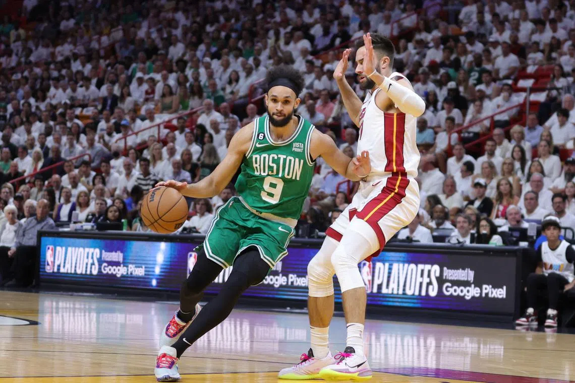 Derrick White of the Boston Celtics dribbles the ball as he is guarded by the Miami Heat's Gabe Vincent in Game 5 of the NBA Eastern Conference Finals.