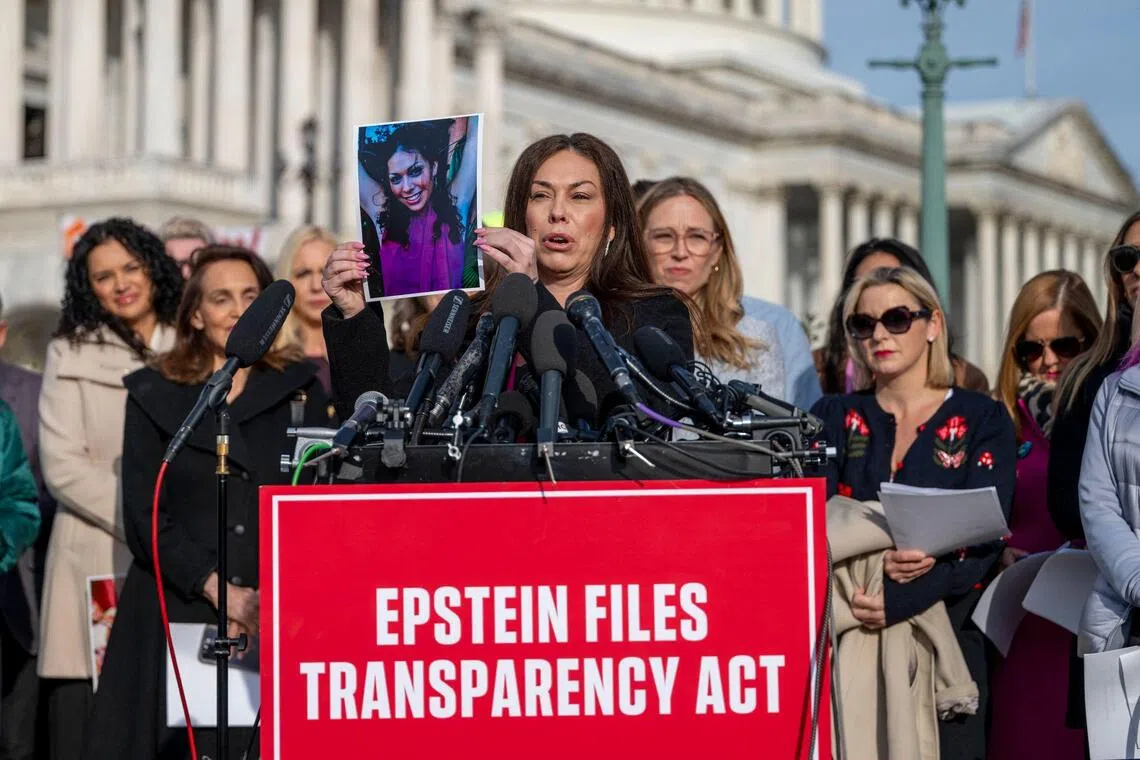 Epstein survivor Haley Robson (centre) holding up a photograph of her younger self during a news conference at the US Capitol in Washington, DC, on Nov 18.