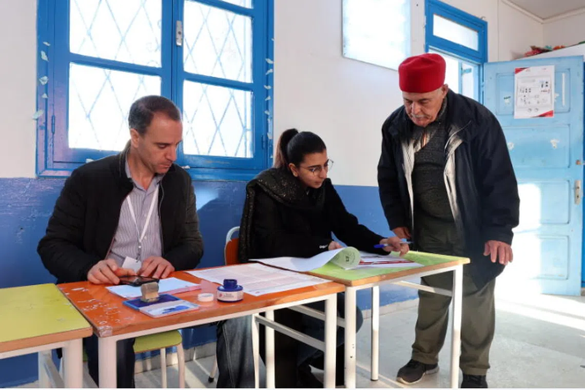 A man checking his personal details as he prepares to cast his vote at a polling station in the Tunisian capital, Tunis.