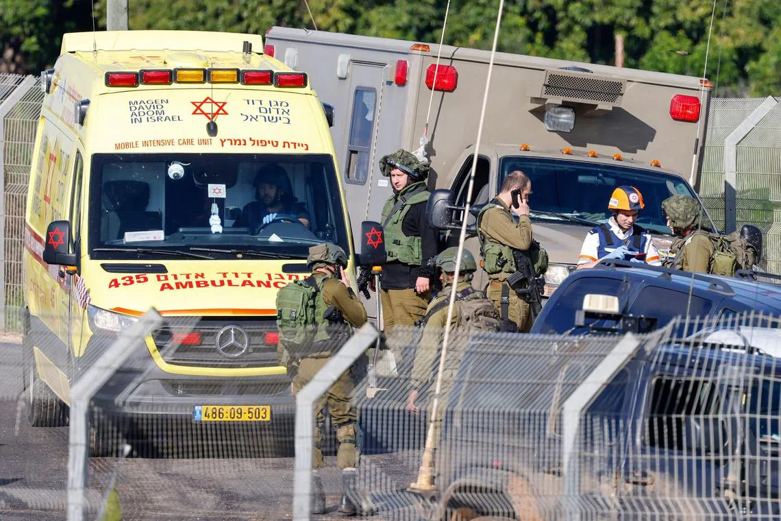 An Israeli ambulance and soldiers are stationed at the entrance of Kfar Yuval, in northern Israel, near the Lebanon border, after it was reportedly targeted with an anti-tank missile from the Lebanese side.
