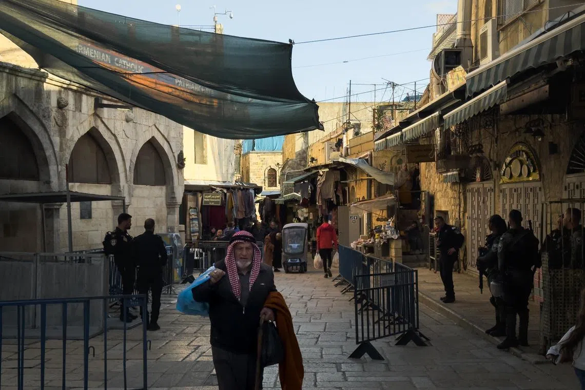 A man walking through a checkpoint guarded by Israeli soldiers in the Jerusalem Old City on March 20, 2024.