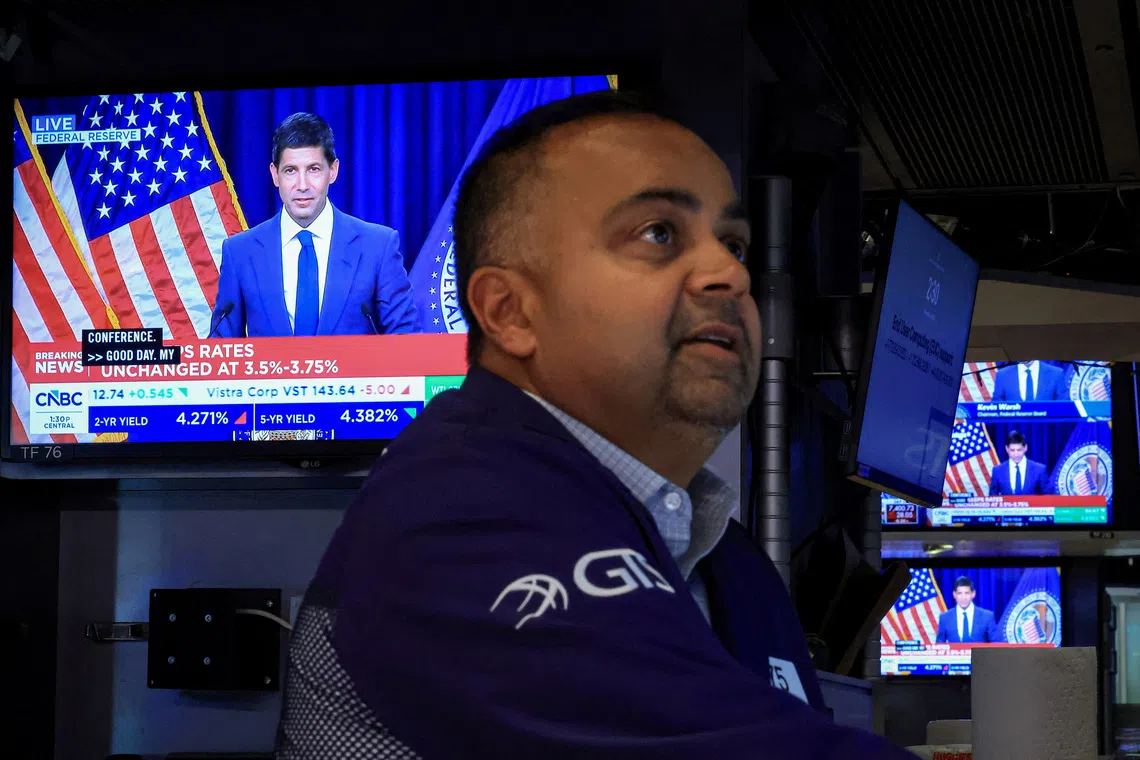 A trader works, as screens broadcast a news conference by US Federal Reserve Chair Kevin Warsh, on the floor of the New York Stock Exchange in New York City.