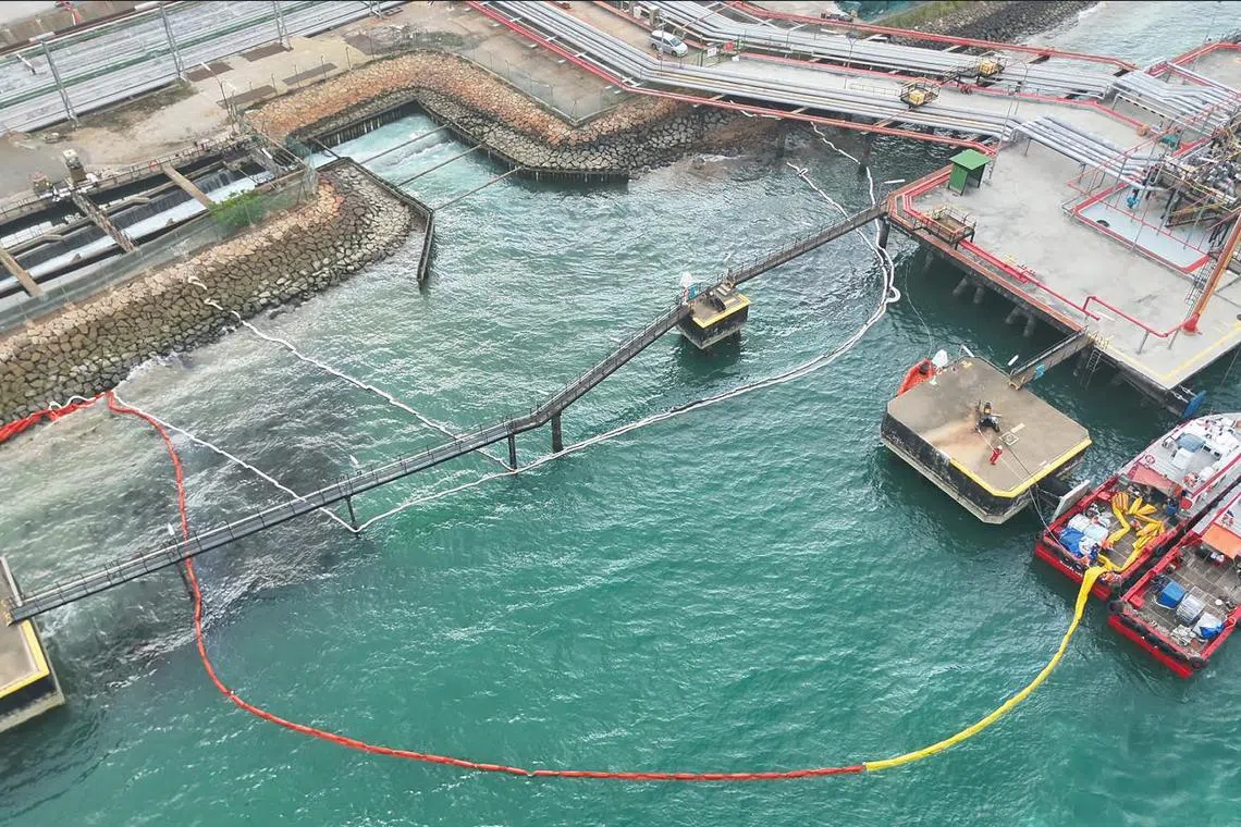 Clean-up operations being conducted on Oct 27 after refined oil products had leaked into the water off Bukom Island.