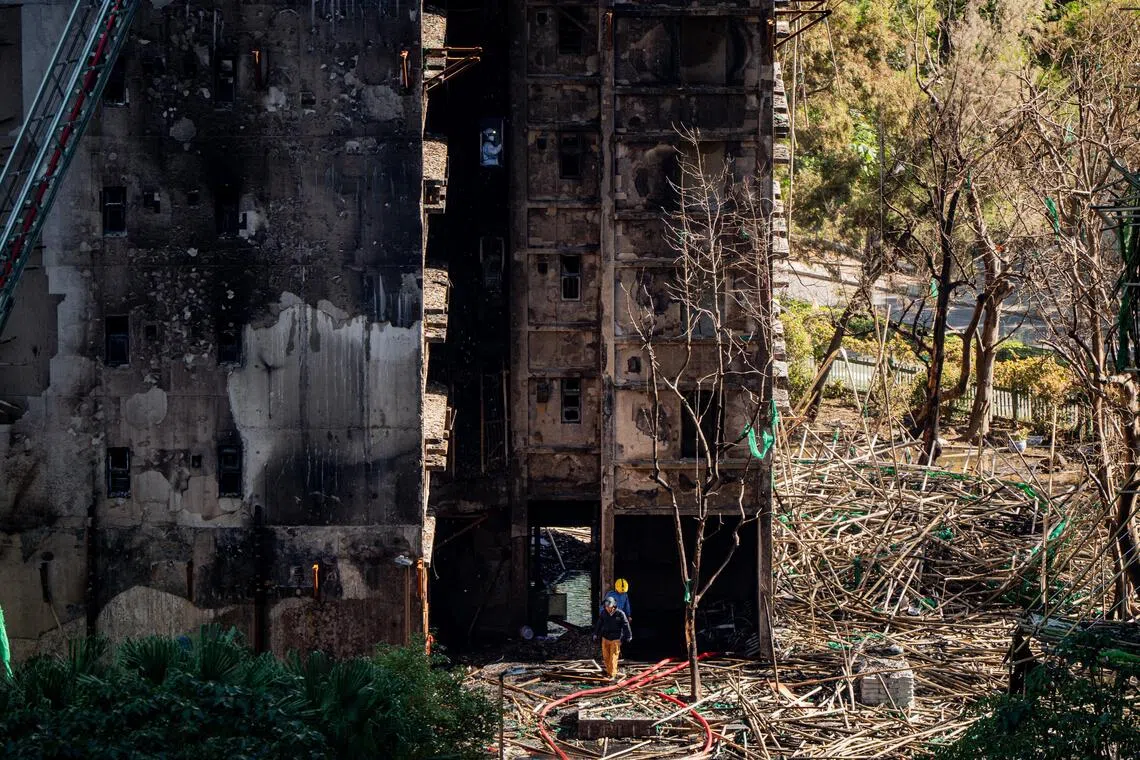 Firefighters and Disaster Victim Identification personnel enter a tower to conduct search and recovery operations.