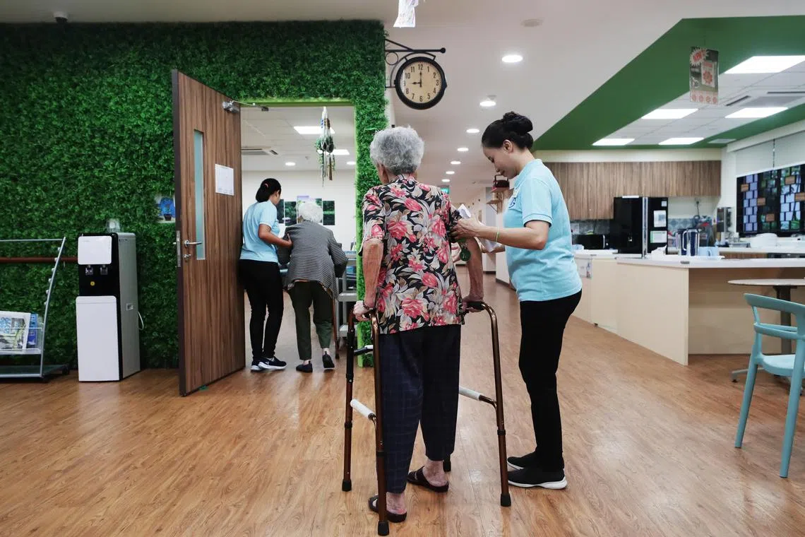 A staff helping an elderly woman at the Ghim Moh Senior Care Centre, Active Ageing Hub, 24 April 2019.
