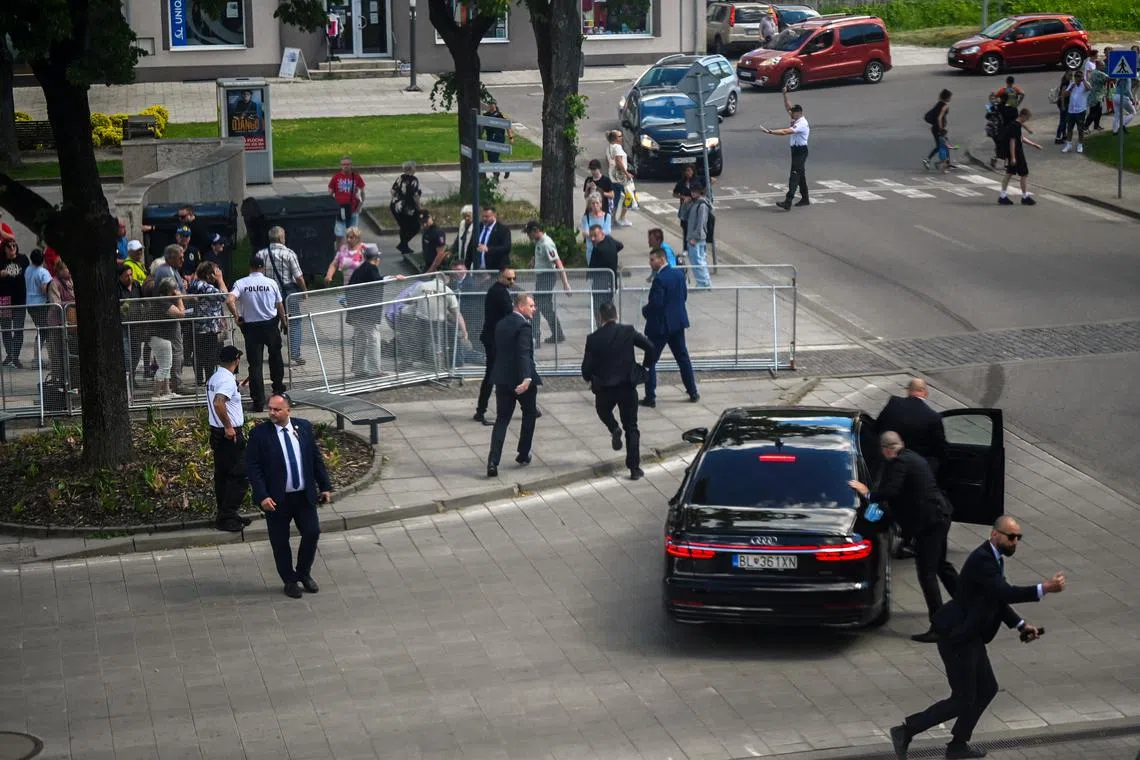 FILE PHOTO: Security officers move Slovakia's Prime Minister Robert Fico into a car after he was shot at close range in an assassination attempt, after a government meeting in Handlova, Slovakia, May 15, 2024. REUTERS/Radovan Stoklasa