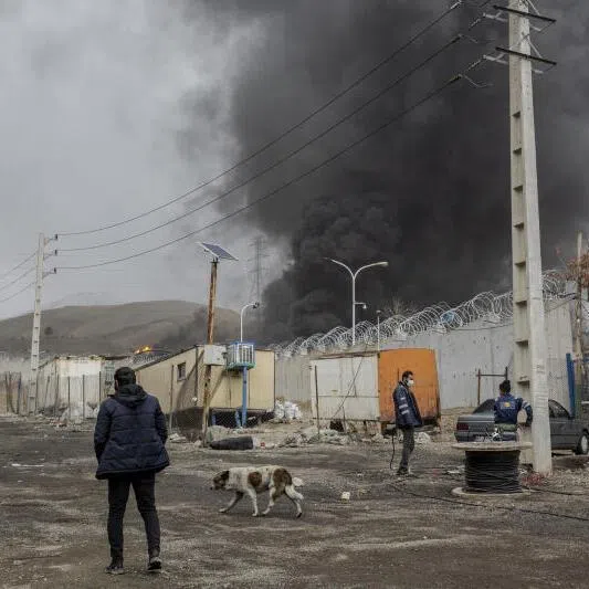 Plumes of smoke rise from an oil storage facility after overnight strikes by US and Israeli forces in Tehran, Iran, on March 8, 2026.