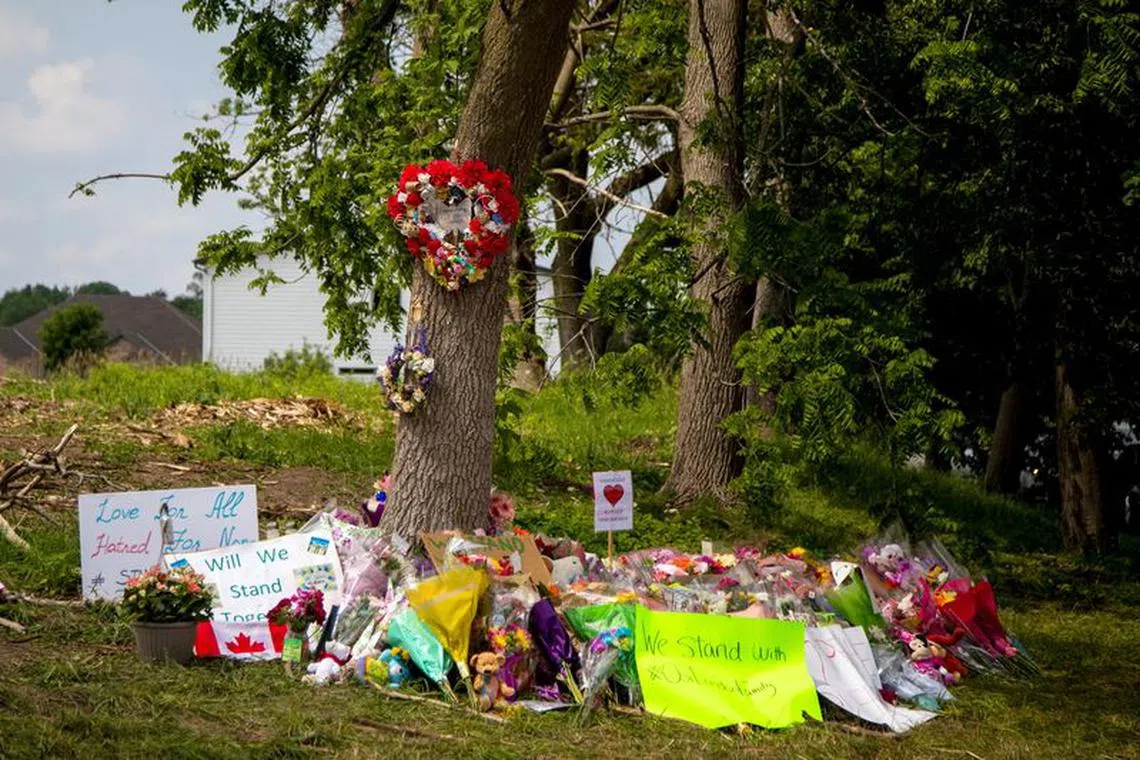 FILE PHOTO: Flowers are left at a makeshift memorial at the fatal crime scene where a man driving a pickup truck jumped the curb and ran over a Muslim family in what police say was a deliberately targeted anti-Islamic hate crime, in London, Ontario, Canada June 9, 2021. REUTERS/Carlos Osorio/File Photo