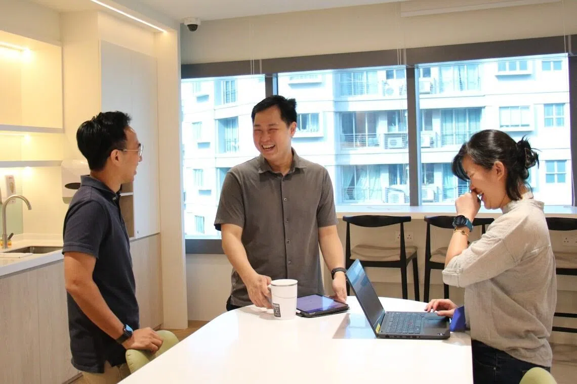 Mr Rafael Tan (middle) spends time with his colleagues in the office pantry to get feedback on how they use office spaces.
