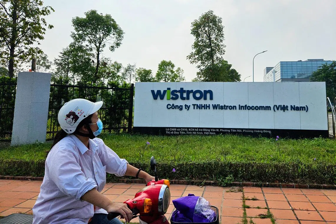 A woman rides a motorcycle past the factory of Wistron NeWeb Corporation in Ha Nam, Vietnam, as the plant expands to produce satellite equipment for SpaceX, October 11, 2024. REUTERS/Khanh Vu