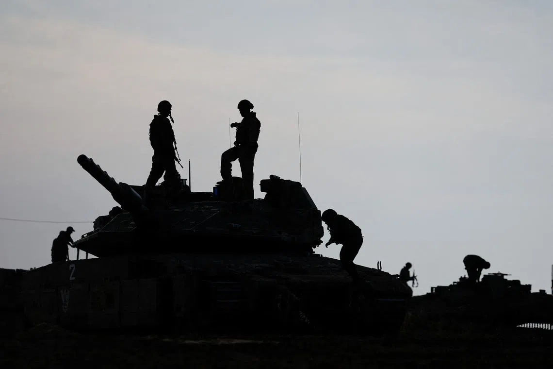 Israeli soldiers are silhouetted as they stand on a tank, near the Israel-Gaza border, amid the ongoing conflict between Israel and the Palestinian Islamist group Hamas, in Israel, May 2, 2024. REUTERS/Amir Cohen/ File Photo