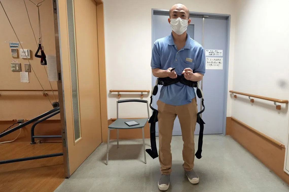 A Shintomi nursing home staff member demonstrating the use of a Honda walking support device at the Shintomi nursing home in Tokyo, Japan on April 7, 2023.