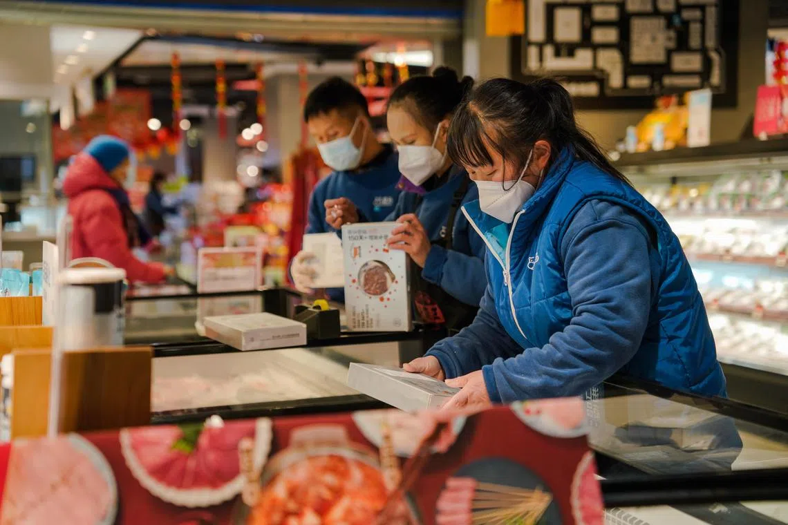 epa10368254 Staff members wearing face masks work at food product area in a supermarket in Beijing, China, 16 December 2022. With easing Covid-19 restrictions, a rising number of infections is circulating in Beijing. People anticipating a winter wave are buying more medicines causing a reportedly shortage of cold and flu medicines across China, as well as home remedies including lemons, canned peaches, and electrolysed water.  EPA-EFE/WU HAO