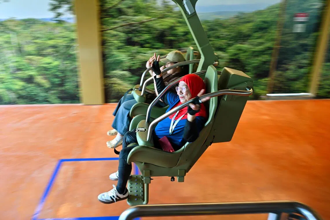 Aisah Binti Ibrahim (right), 79, member of Disabled People’s Association, riding the Canopy Glider with the help of her caregiver Sri Lestari (left), 30, at Rainforest Wild Adventure East on Sept 15.